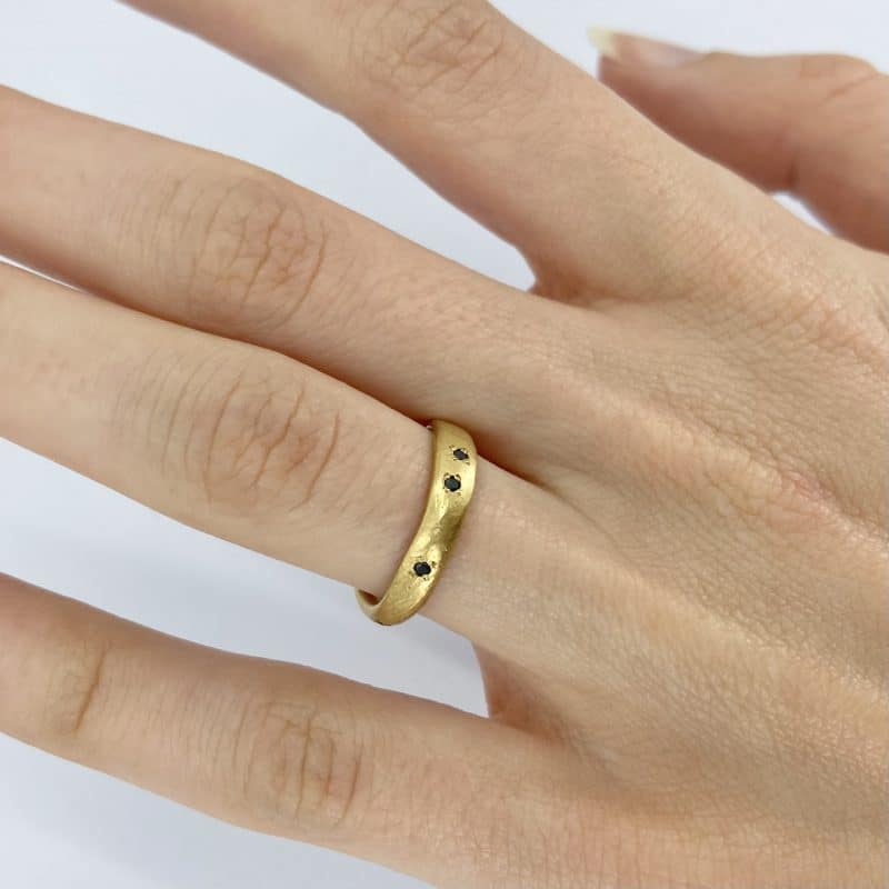 gold organic form black diamond ring on the body