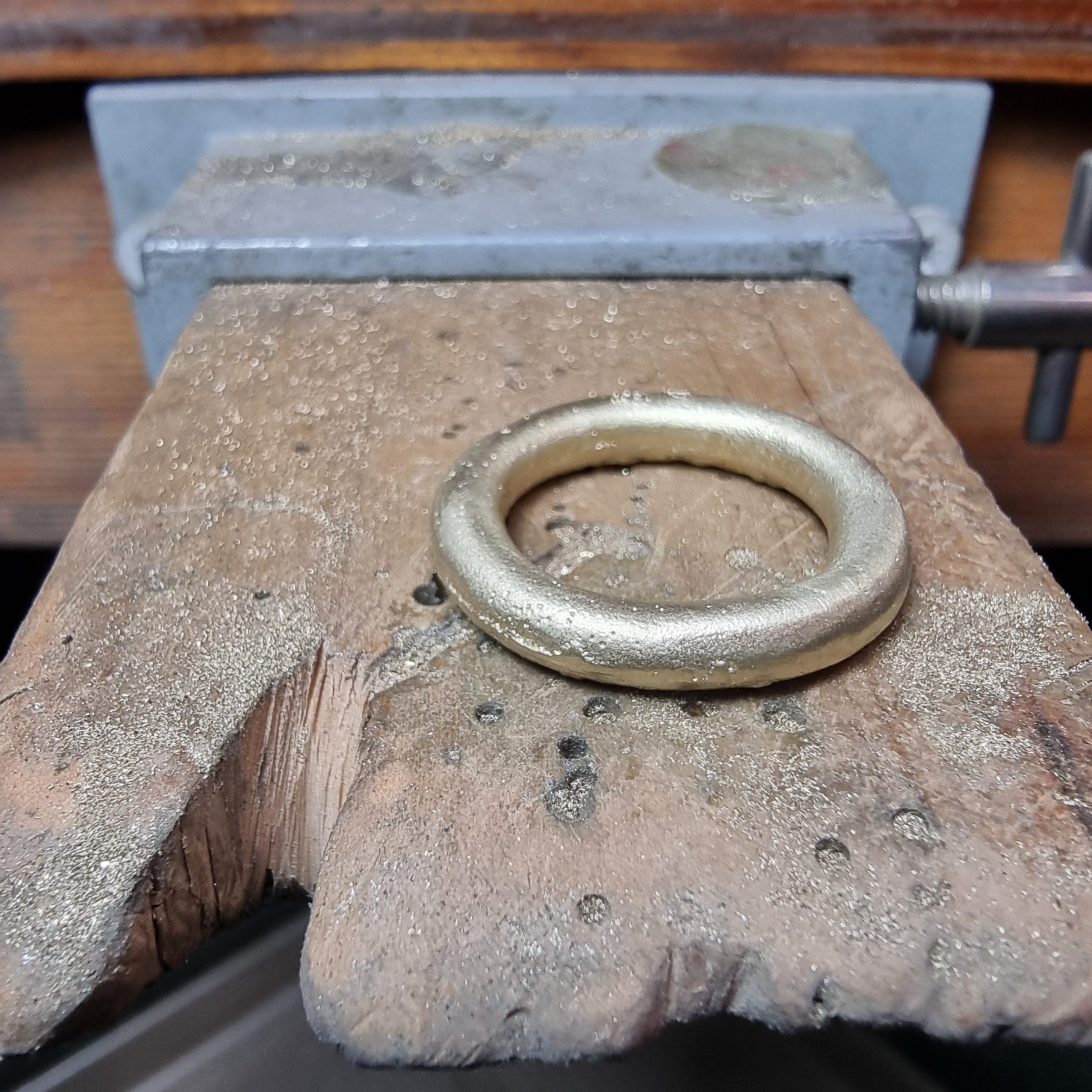 gold donut ring sitting on bench peg